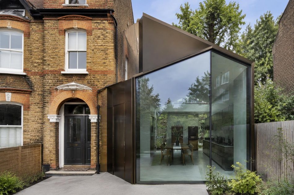 Victorian brick house beside a bronze metal and glass extension in Ladywell