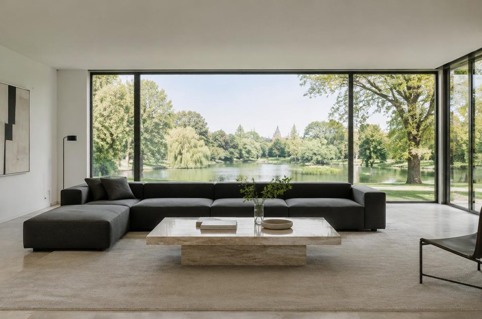 Living room with broad glazing onto a park lake in Lee