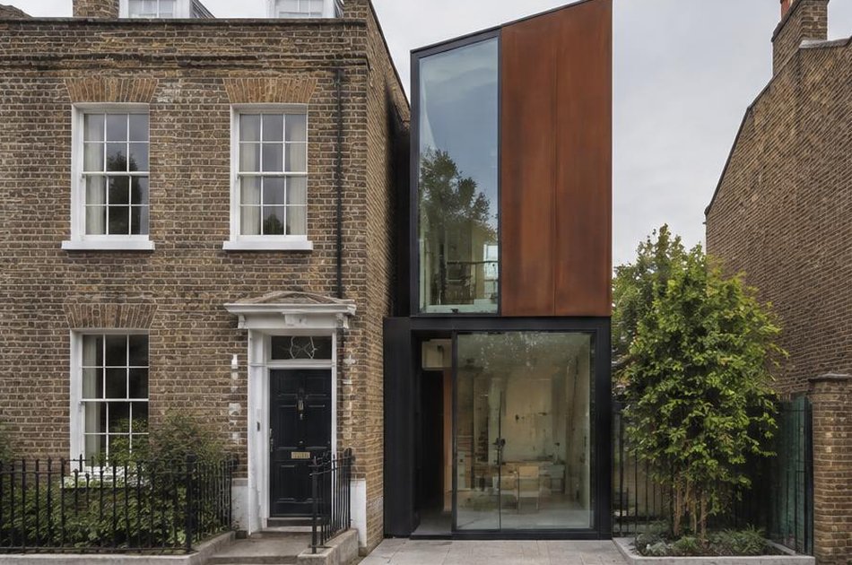 Georgian brick house beside a contemporary corten and glass infill house in Lewisham