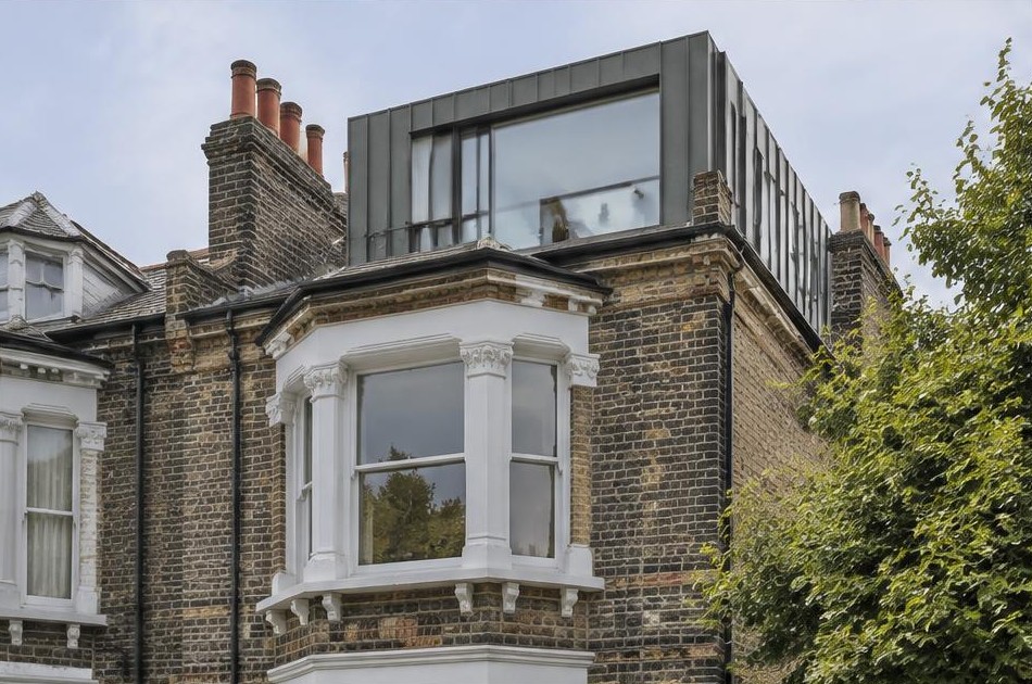 Retained original facade beside a dominant contemporary glazed addition in London Fields