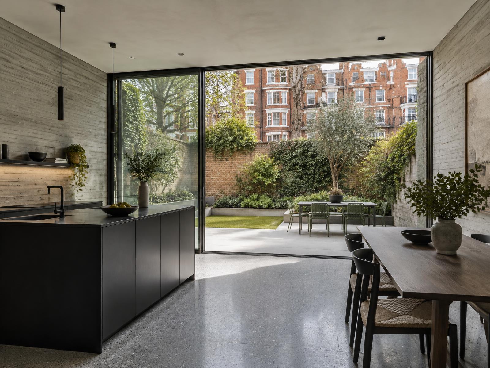 New garden room with board-marked concrete walls opening onto a walled garden below Maida Vale mansion blocks