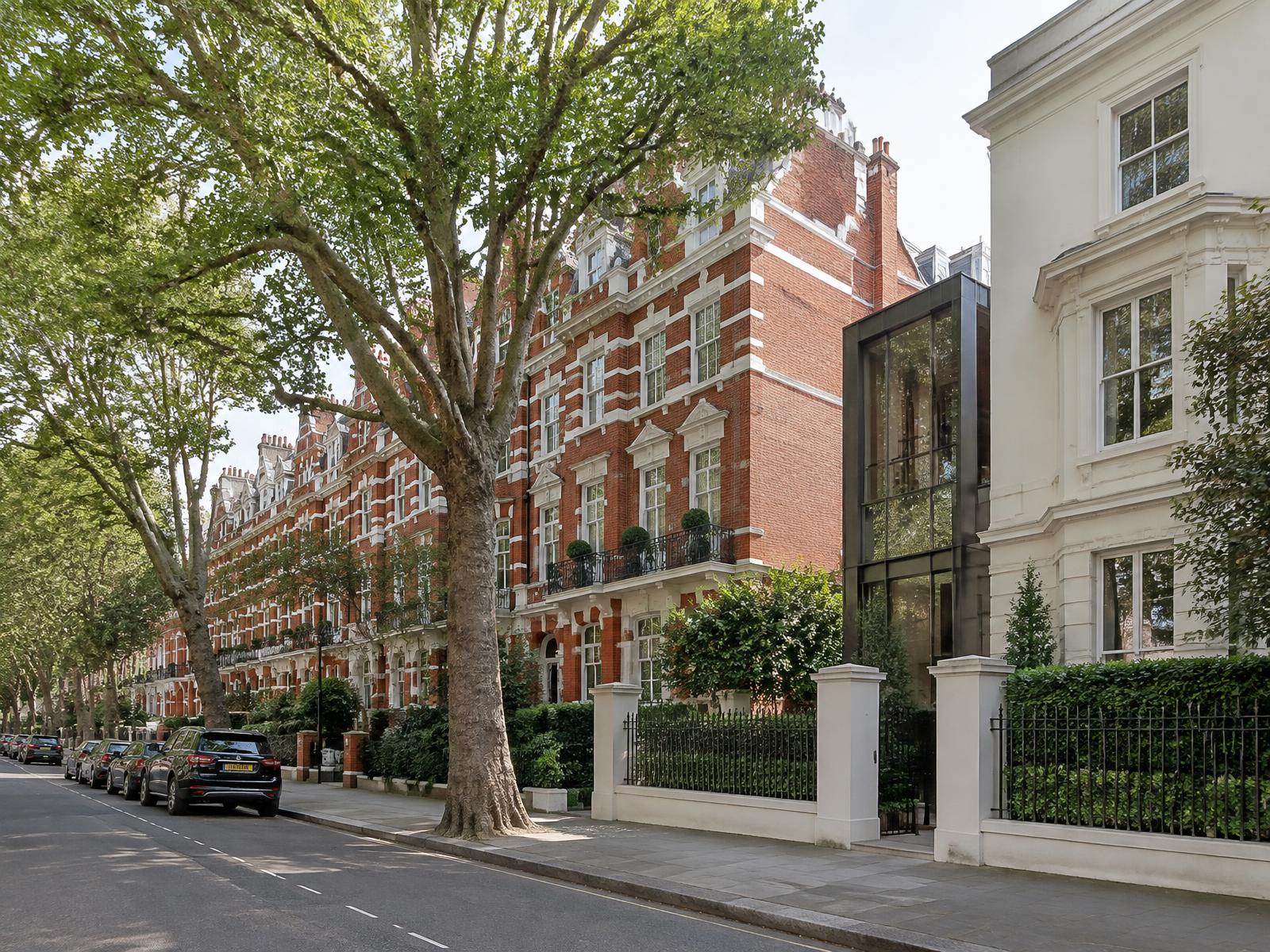 Tree-lined Maida Vale avenue of red-brick mansion blocks beside a stucco villa with a dark glass extension