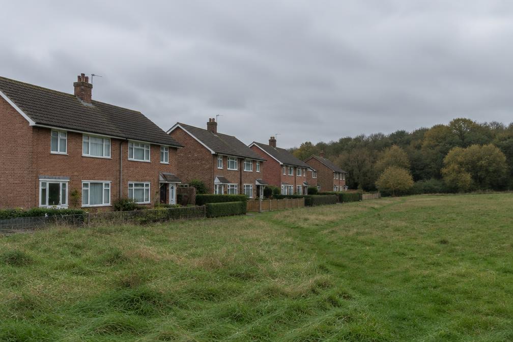 Post-war houses beside open grassland at the edge of the city