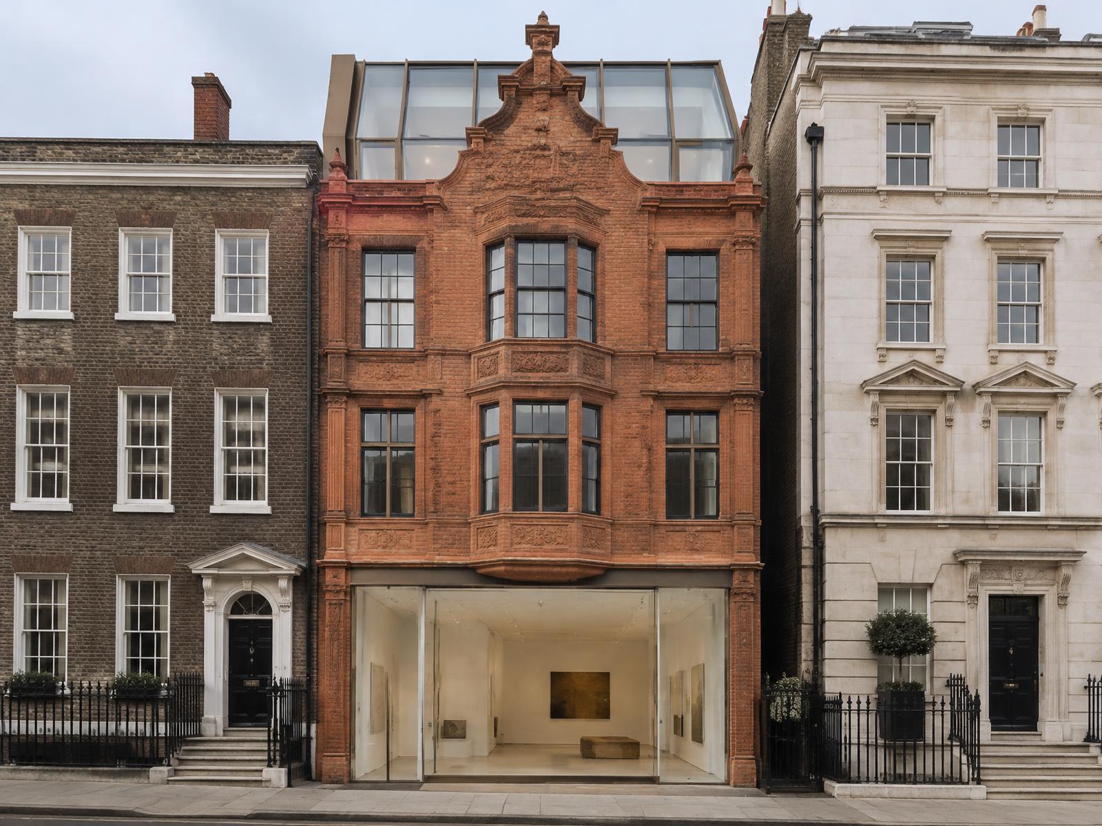 Red-brick Queen Anne Mayfair townhouse with a frameless glass gallery frontage and glazed roof addition between Georgian neighbours