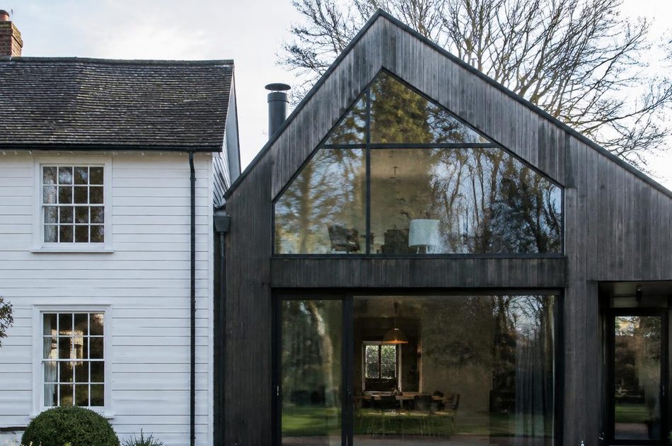 Weatherboarded Georgian cottage beside a blackened timber and glass extension in Mitcham