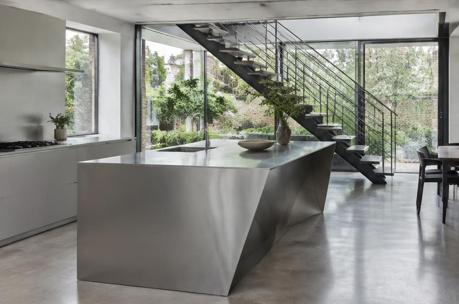 Completed contemporary kitchen with open staircase and garden glazing in Mortlake