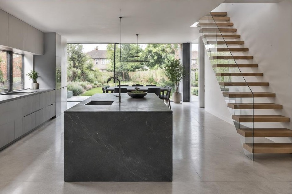 Completed contemporary kitchen with open staircase and garden glazing in Motspur Park
