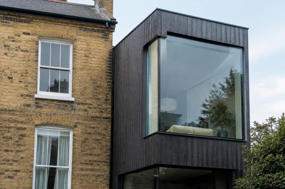 Victorian stock brick terrace beside a charred timber extension in New Cross