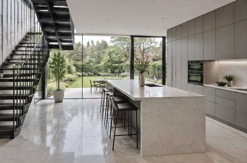 Completed contemporary kitchen with open staircase and garden glazing in Norbiton