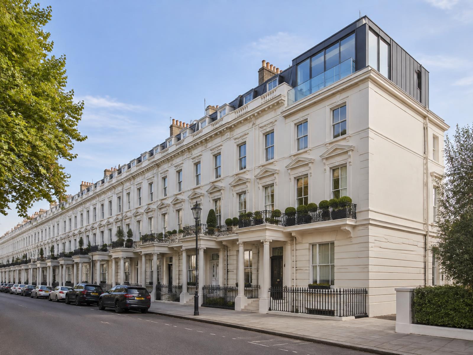 Long white stucco Paddington terrace with a contemporary zinc and glass roof addition on the end house