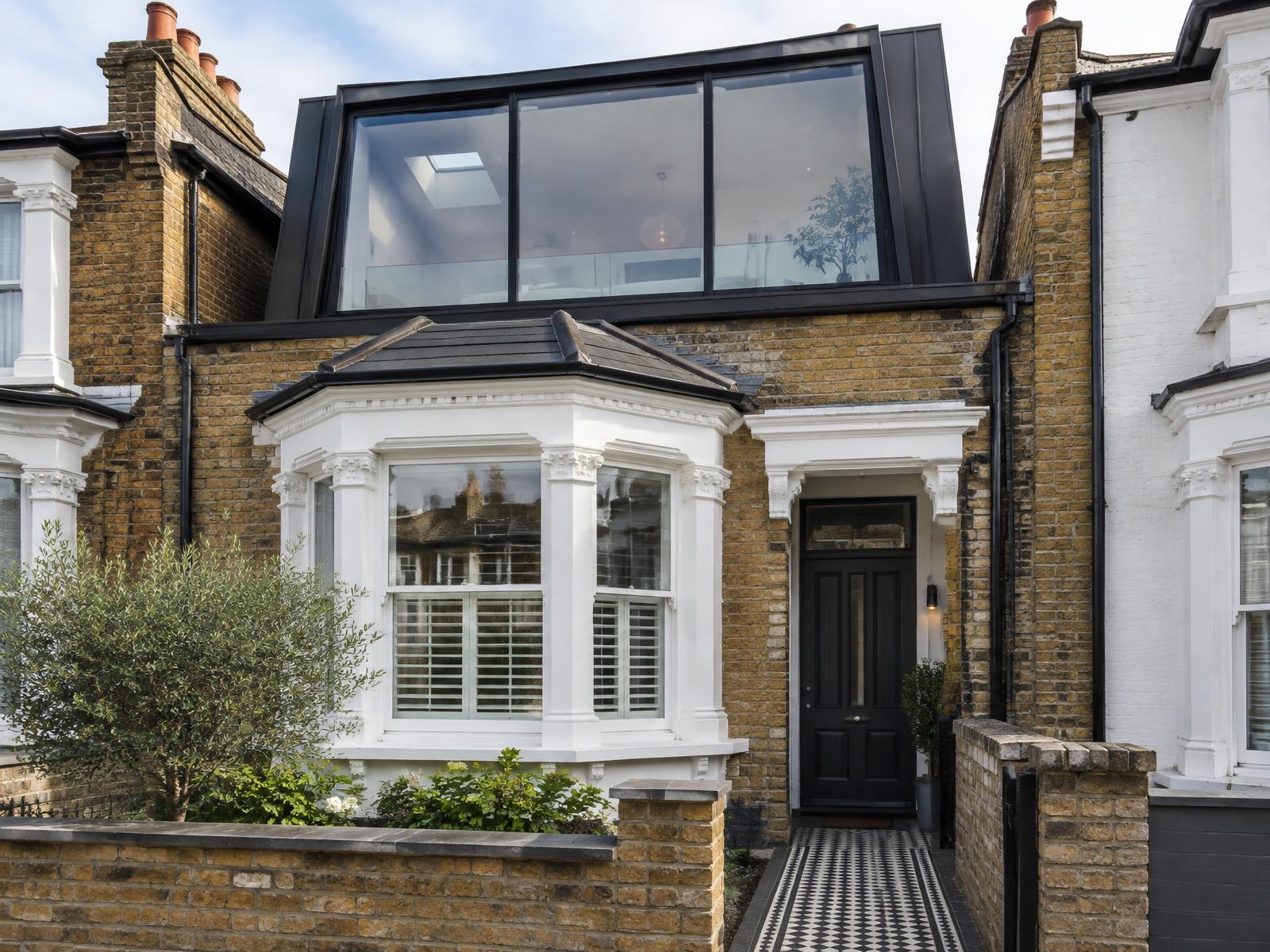 Victorian terrace house with a white bay window and a contemporary glazed zinc roof extension above