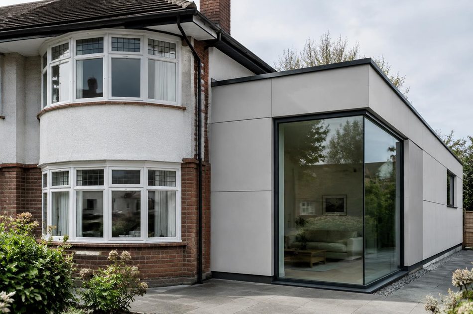 Interwar semi with curved bay beside a panel-clad glass extension in Perivale