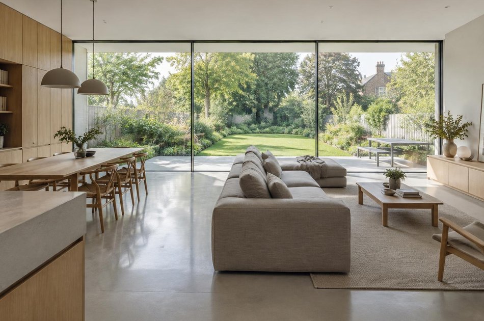 Open-plan living space with full-width glazing onto a long garden in Raynes Park