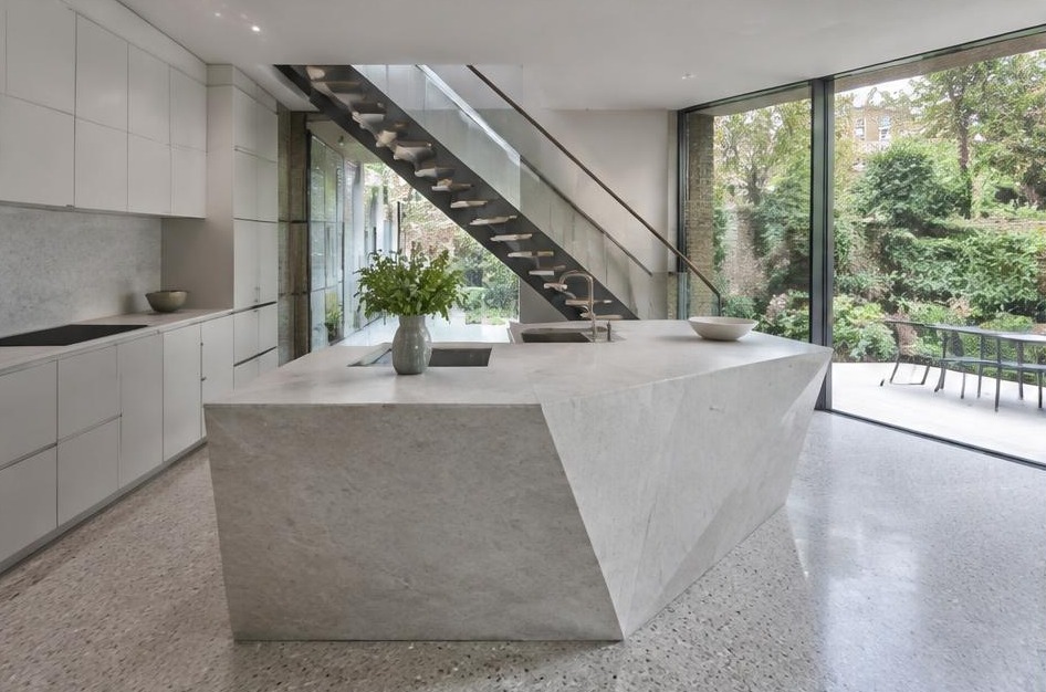 Completed contemporary kitchen with open staircase and garden glazing in Richmond upon Thames