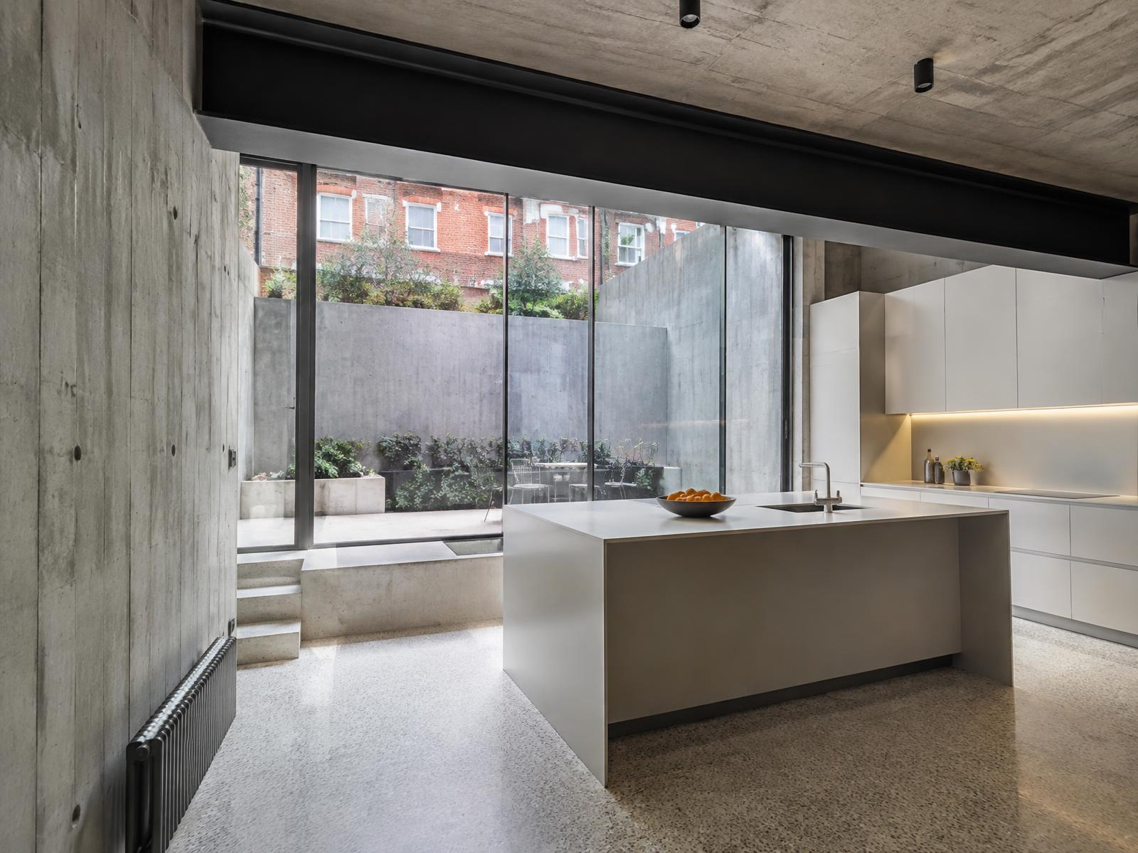New lower ground kitchen with board-marked concrete and glazing onto a lightwell courtyard
