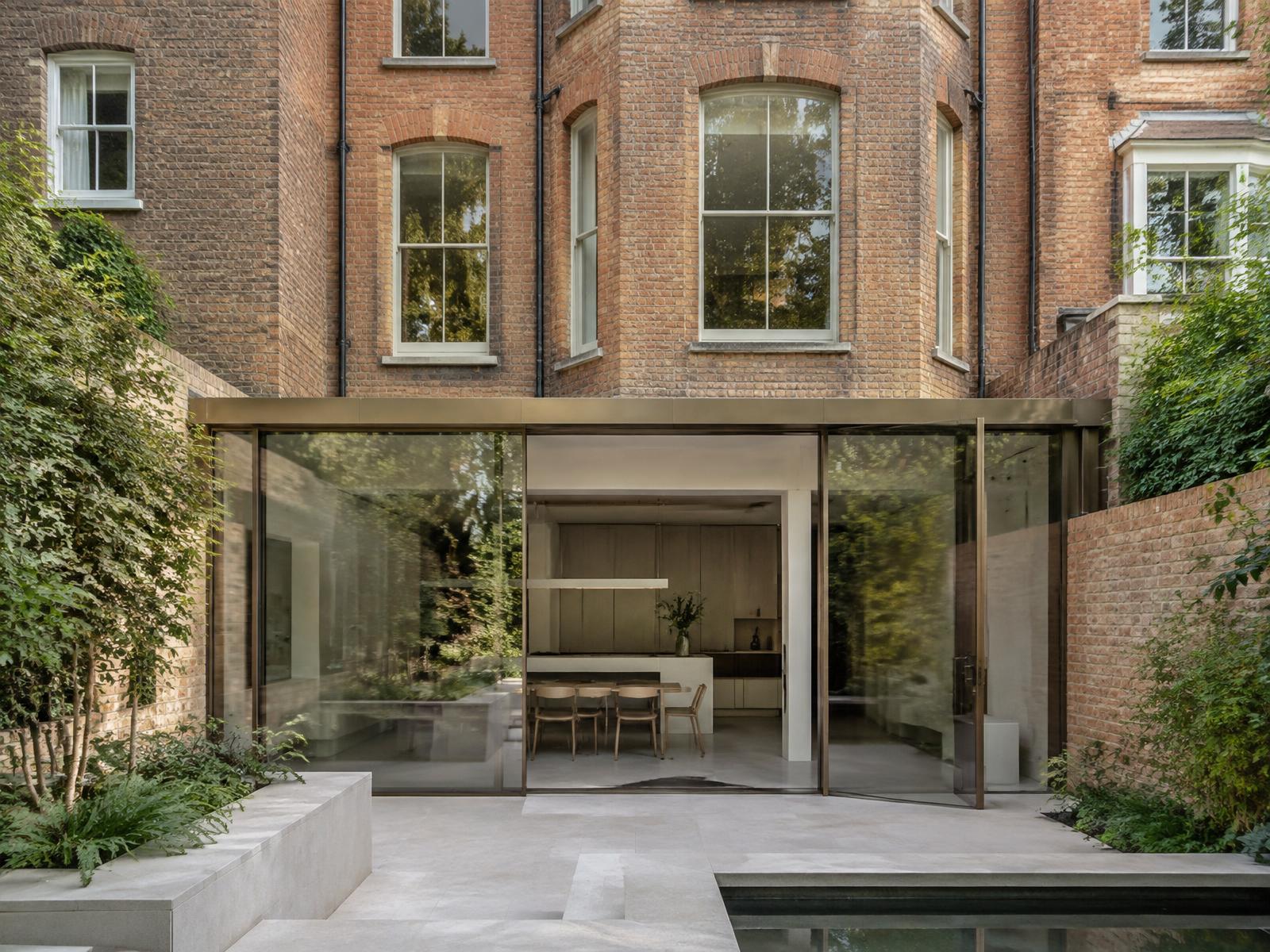Red brick Victorian townhouse with a bronze-framed glass garden extension
