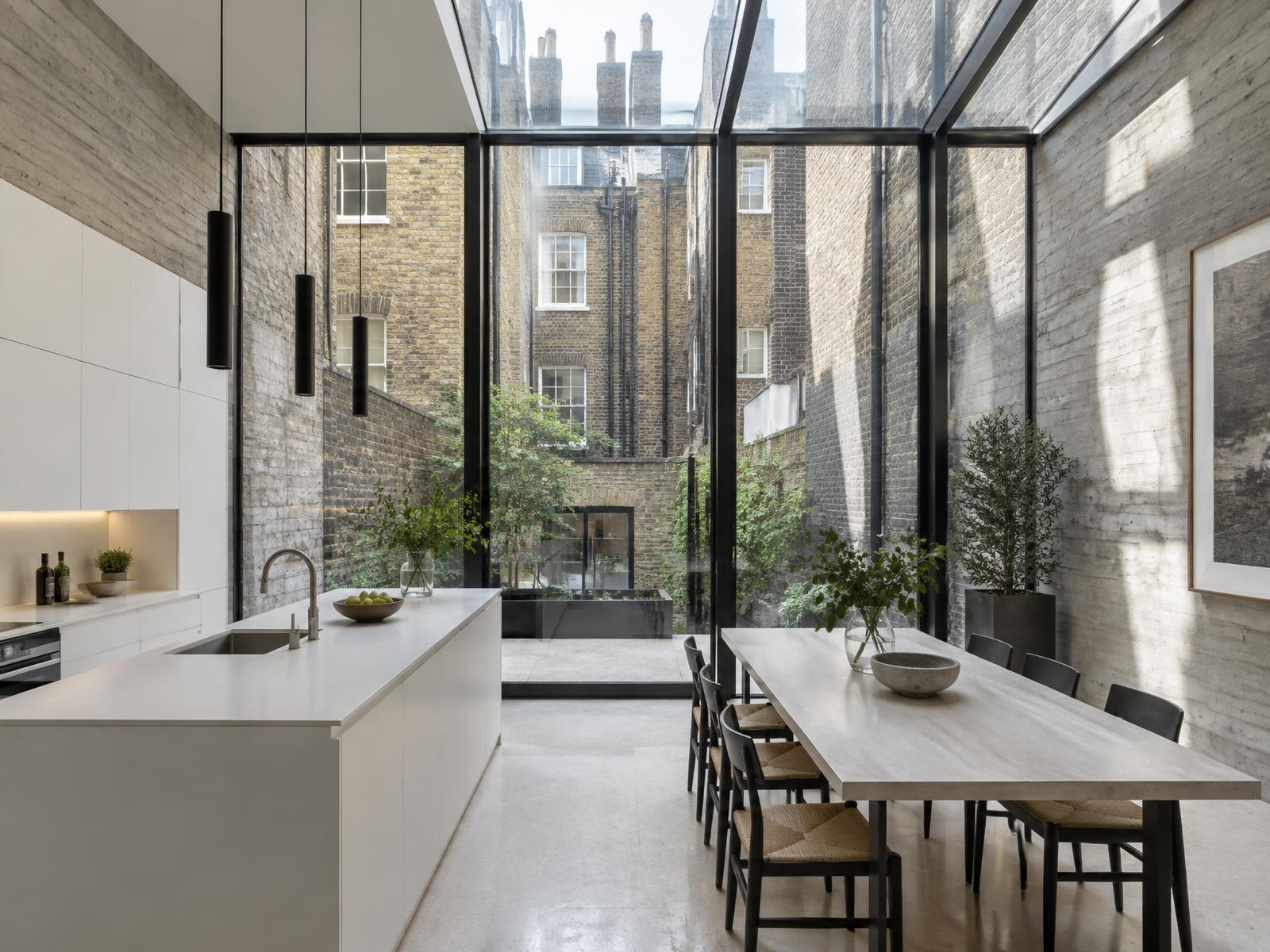 New glazed rear extension with concrete walls and a kitchen looking onto a Soho lightwell courtyard