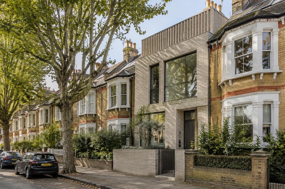 Tree-lined Edwardian terraced street with a contemporary pale brick house in South Wimbledon