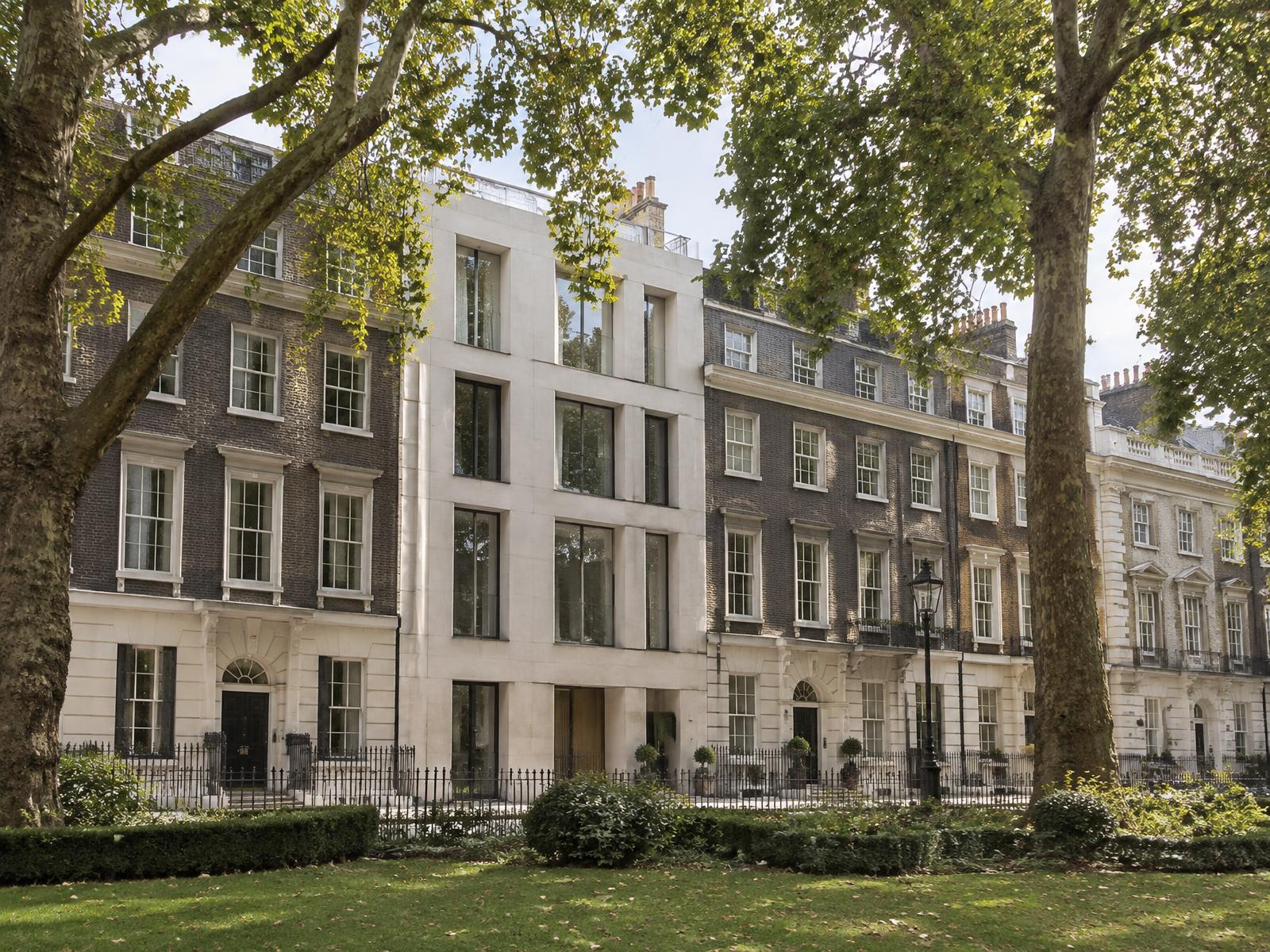 St James's Square townhouses with a minimalist pale stone contemporary infill matching the parapet line
