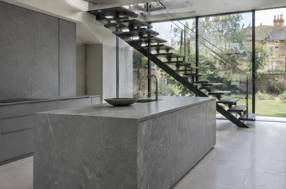 Completed contemporary kitchen with open staircase and garden glazing in St Margaret's
