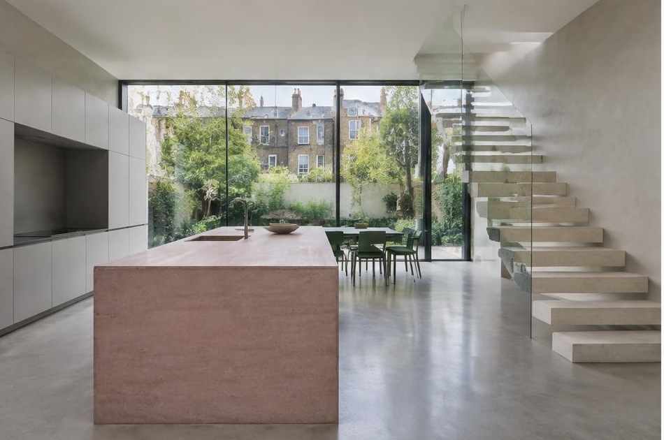 Contemporary kitchen with an open staircase and glazing onto a residential garden in Stockwell