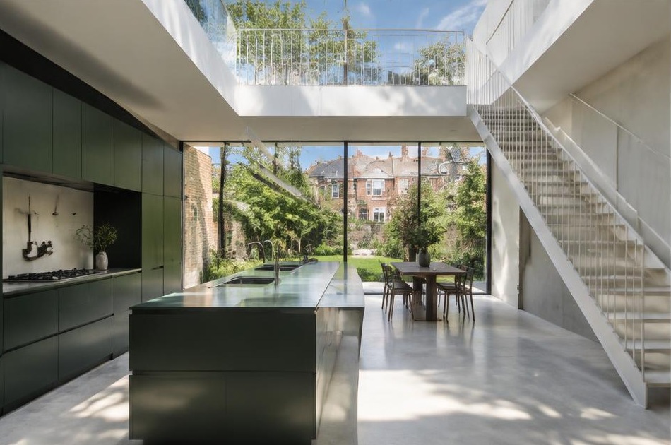 Contemporary kitchen with an open staircase and glazing onto a residential garden in Streatham