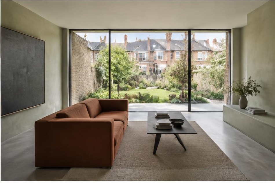 Minimalist contemporary room with straight fabric seating and views onto Streatham residential homes and gardens
