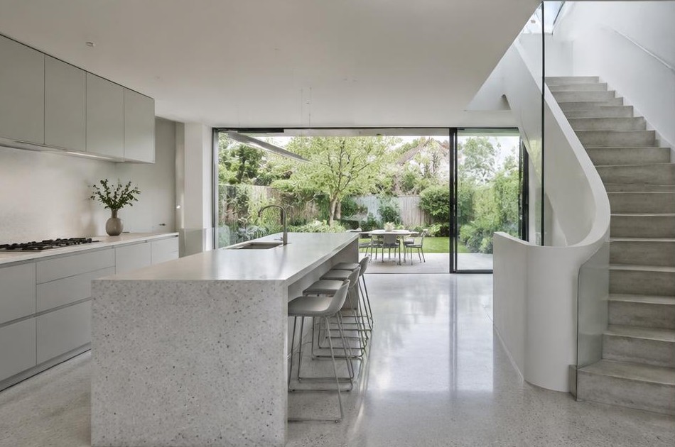 Completed contemporary kitchen with open staircase and garden glazing in Surbiton