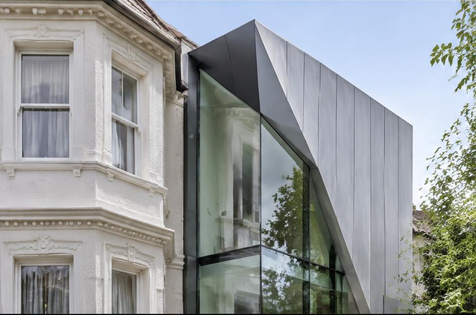 Retained original facade beside a dominant contemporary glazed addition in Surbiton