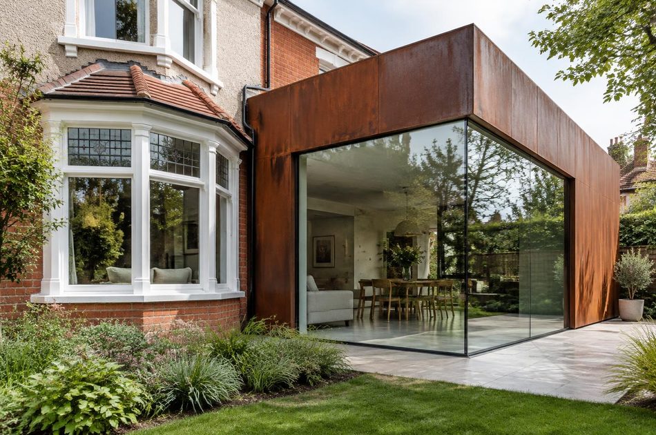 Edwardian villa bay window beside a corten steel and glass extension in Sydenham