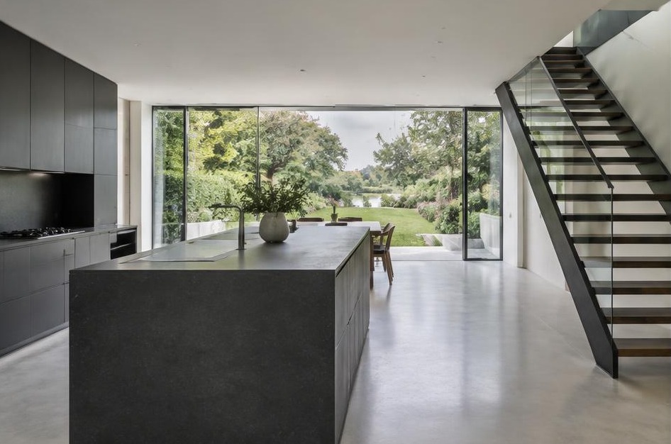 Completed contemporary kitchen with open staircase and garden glazing in Teddington