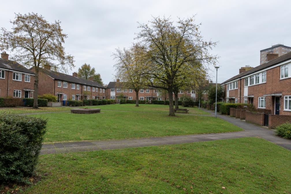 Low-rise post-war housing estate with brick terraces and green spaces