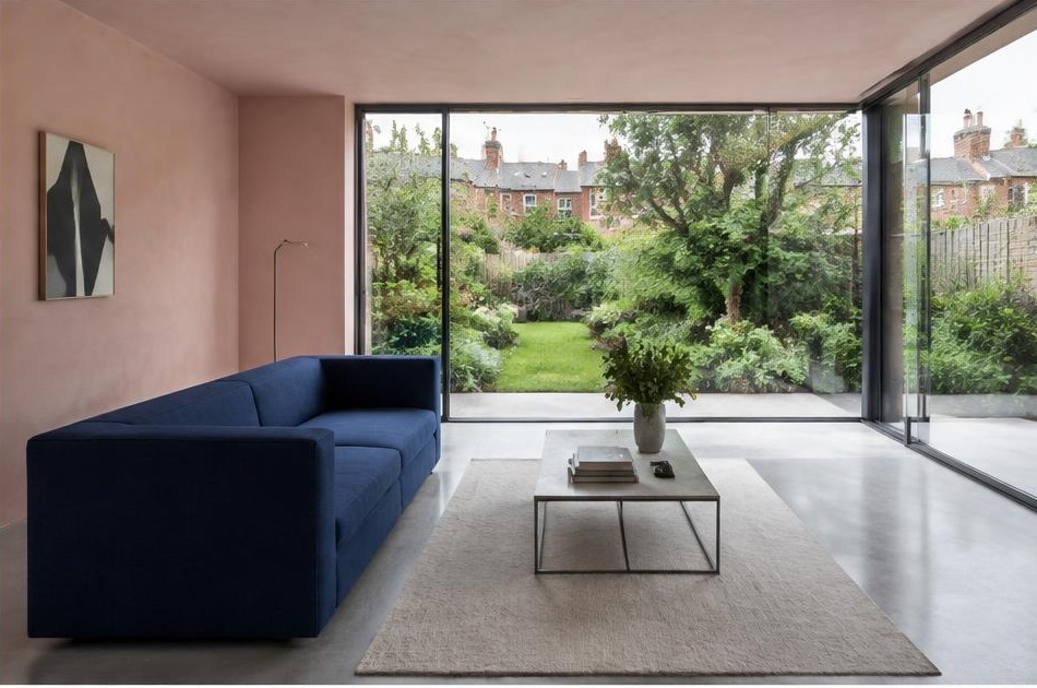 Minimalist contemporary room with straight fabric seating and views onto Tooting residential homes and gardens