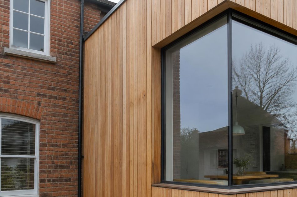 Red-brick house beside a larch-clad extension in Tottenham Hale