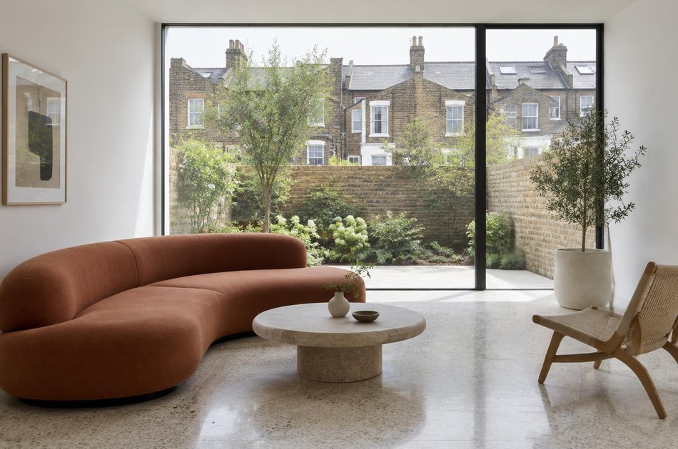 Living room with a curved sofa opening onto a courtyard in Tottenham