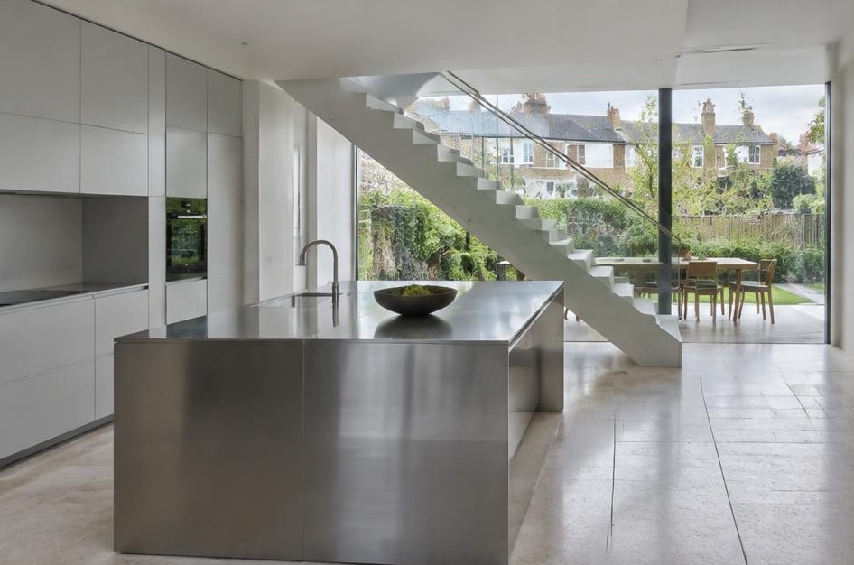 Completed contemporary kitchen with open staircase and garden glazing in Twickenham