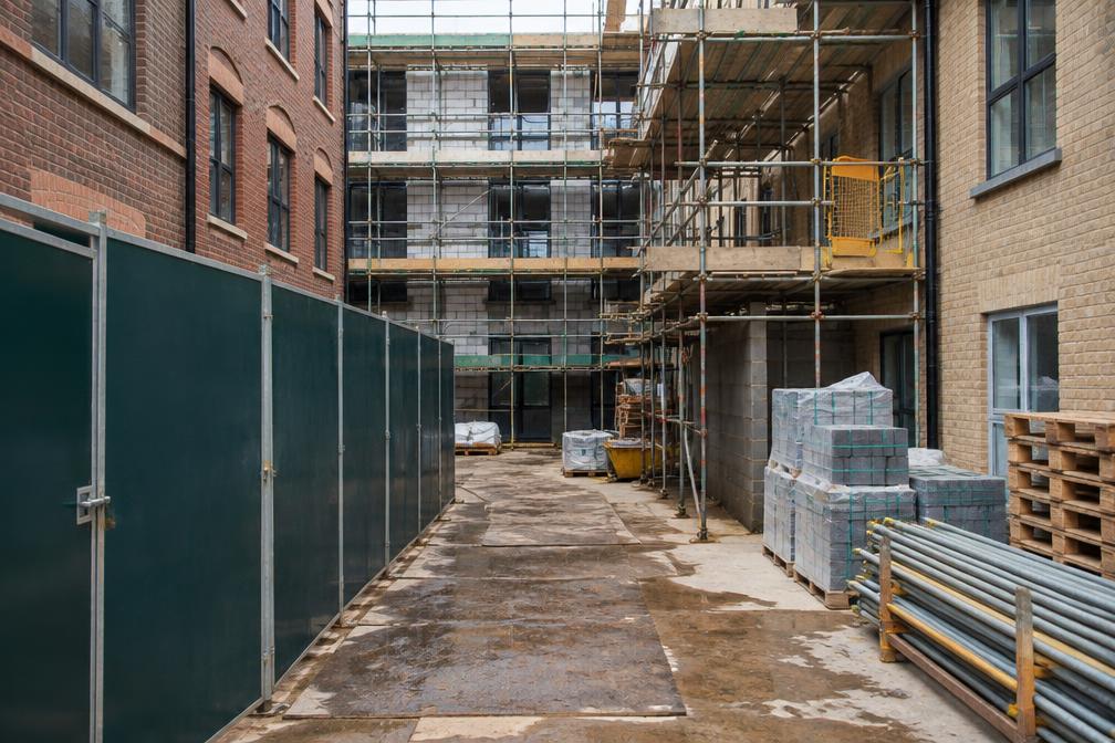 Town-centre building site with scaffolding and hoarding in Uxbridge