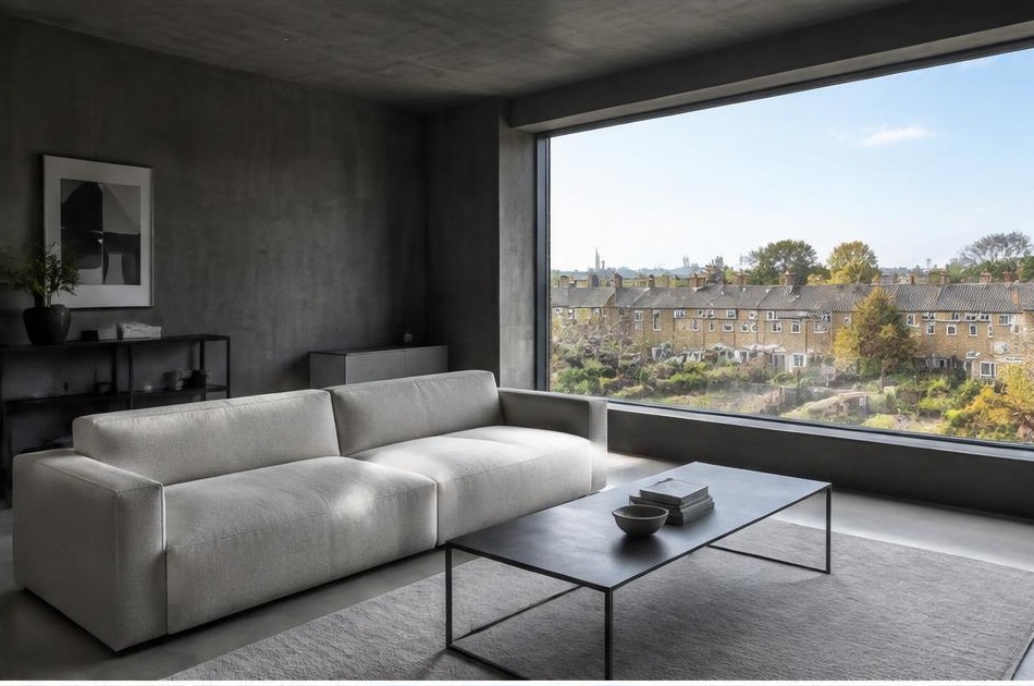 Minimalist contemporary room with straight fabric seating and views onto Vauxhall residential homes and gardens