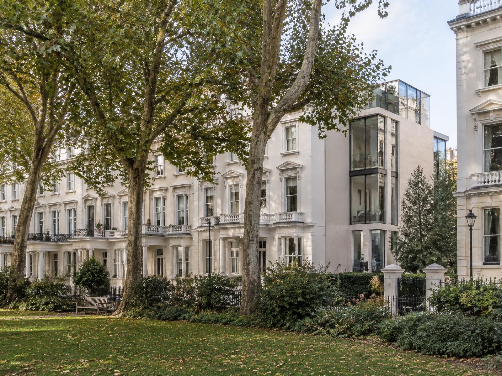 Victoria garden square of white stucco terraces with a contemporary stone and glass end-house extension