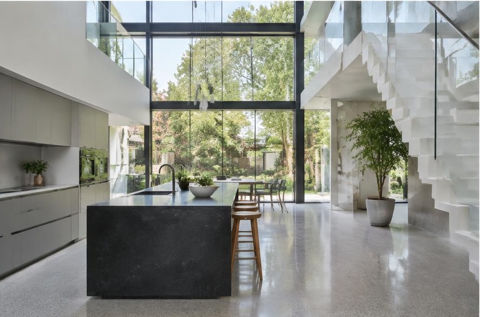Contemporary kitchen with open staircase and glazing onto a residential garden in Wandsworth Common