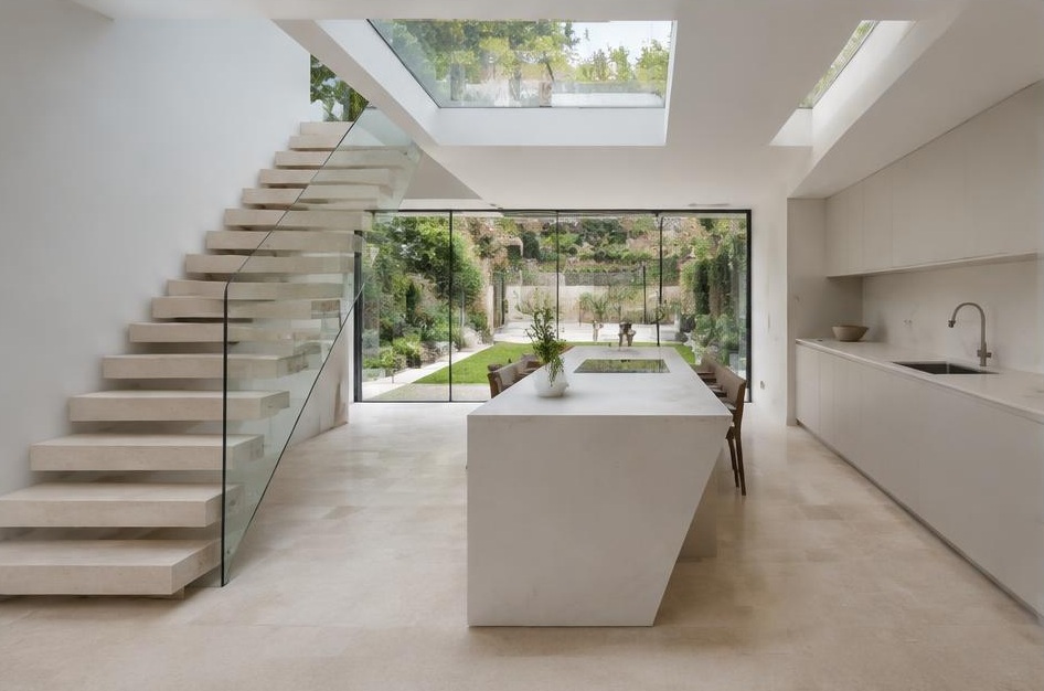 Contemporary kitchen with open staircase and glazing onto a residential garden in Balham