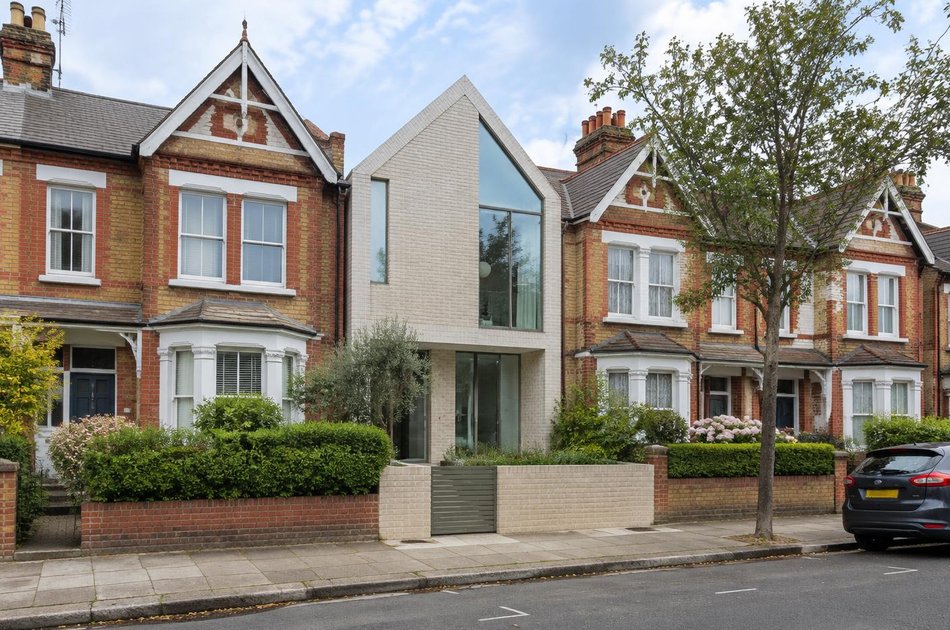 Pale brick contemporary house among Noel Park terraces in Wood Green