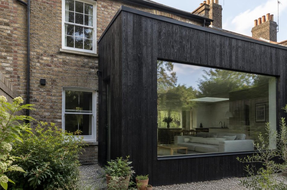 Cottage terrace beside a charred-timber rear extension in Wood Green