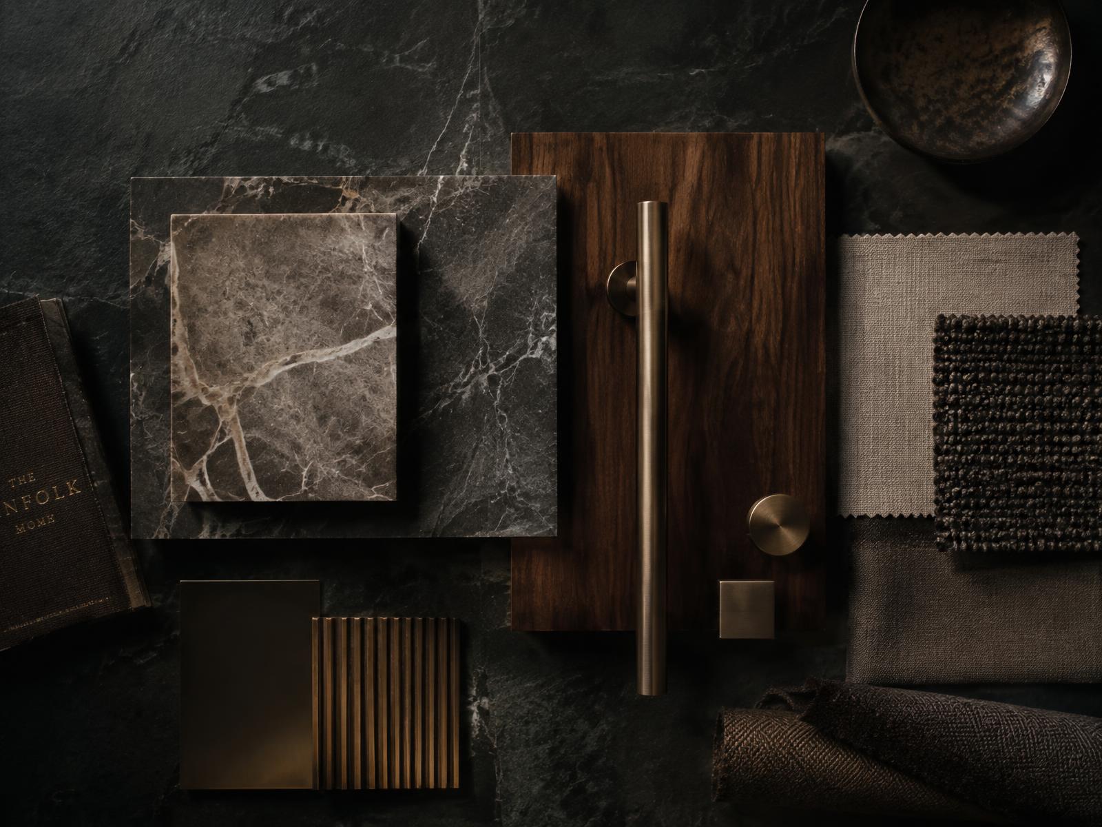 Dark marble, walnut, bronze and linen material samples arranged on slate for a bespoke residence